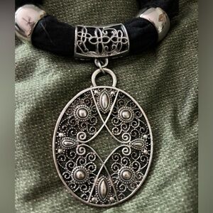 Vintage scarf pendant, oval 2”X 2.5”, with two gold tone rings.